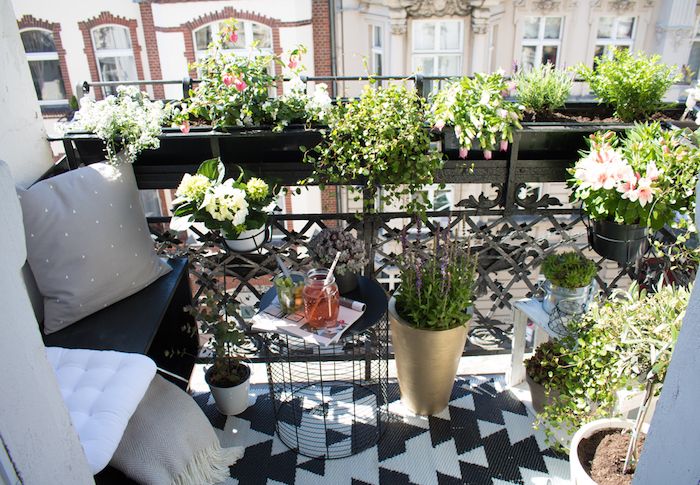 idee-terrasse-à-aménager-soi-meme-revêtement-blanc-et-noir-petite-assise-noire-table-balles-coussins-gris-et-plusieurs-plantes-et-fleurs [Kiến thức] Thiết kế ban công chung cư đẹp